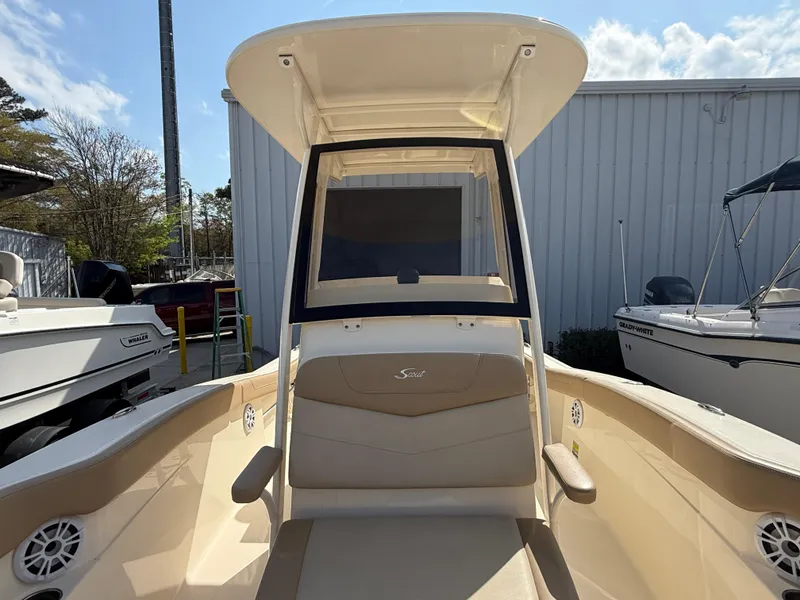 Slide: The Image of 2023 Scout 215 XSF boat with beige seating and T-top, docked outdoors. - 24