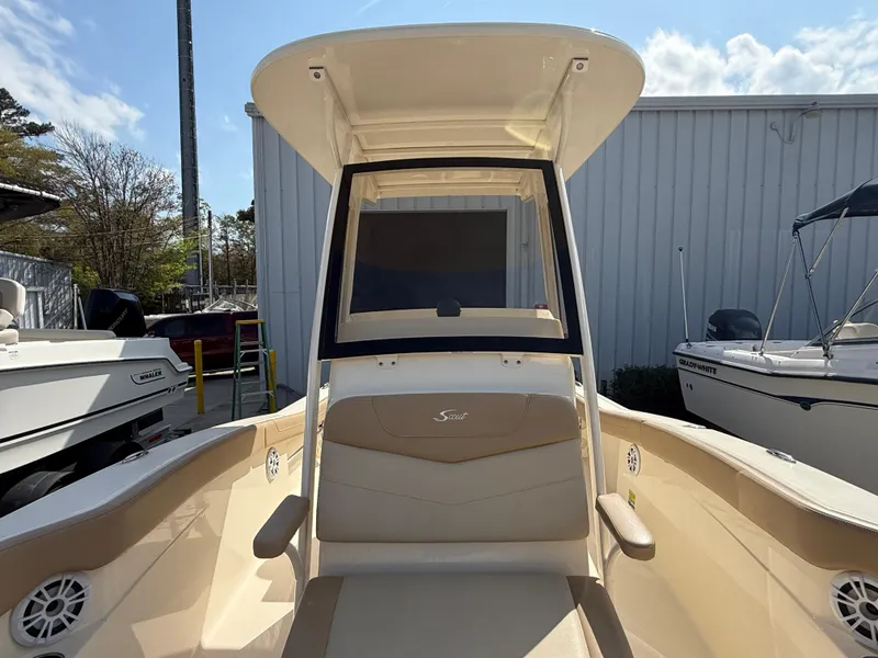 Slide: The Image of 2023 Scout 215 XSF boat with beige seating and T-top, docked outdoors. - 28