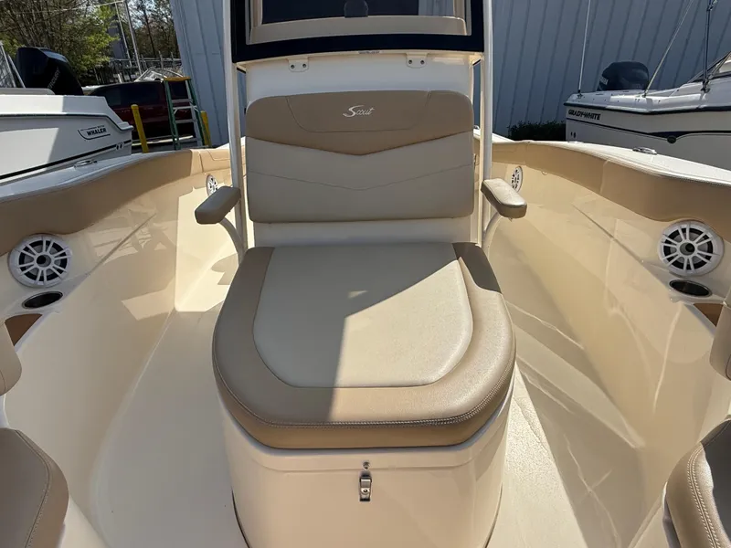 Slide: The Image of 2023 Scout 215 XSF boat interior with beige seating and speakers. - 29