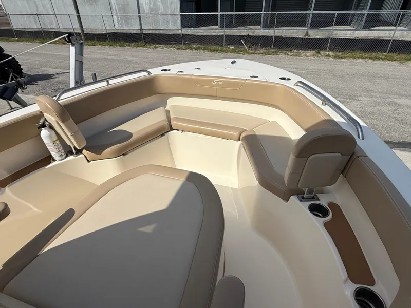 Slide: The Image of 2023 Scout 215 XSF boat interior with beige seating and cup holders. - 44