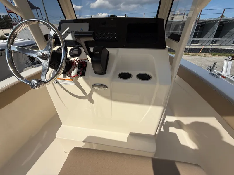 Slide: The Image of 2023 Scout 215 XSF boat console with steering wheel and controls, featuring a sleek design. - 48
