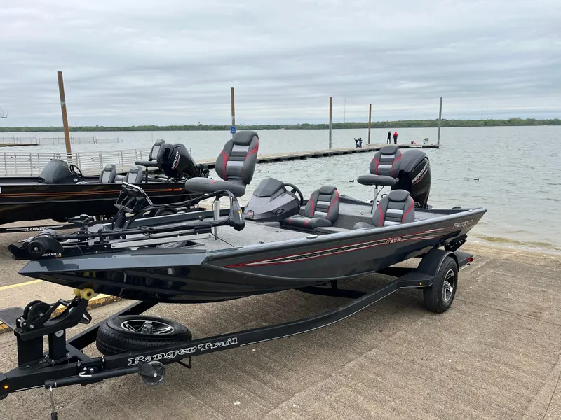 Slide: The Image of 2023 Ranger RT178 boat on trailer by a lake, ready for launch. - 0