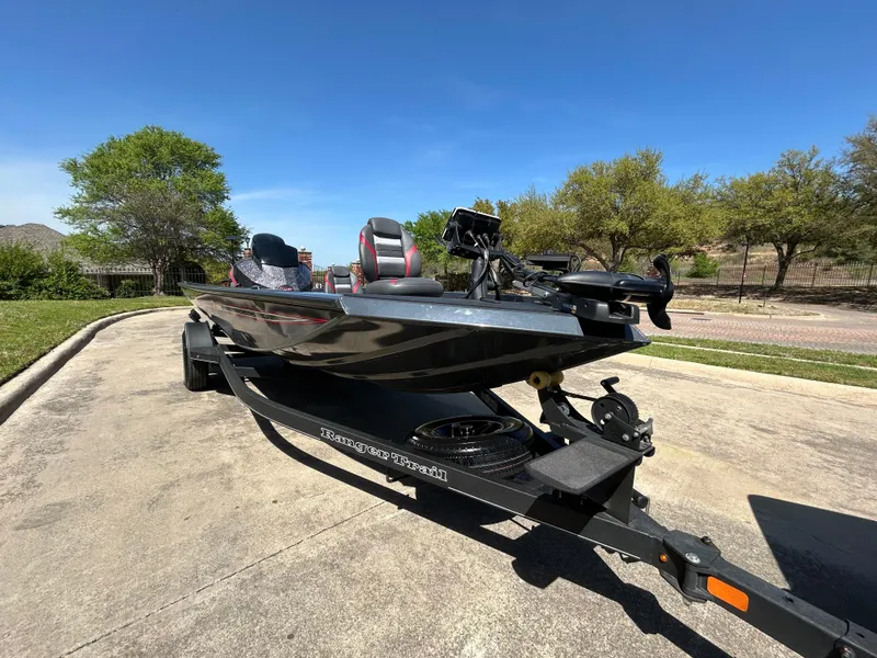 Slide: The Image of 2023 Ranger RT178 boat on trailer, parked outdoors under clear blue sky. - 1
