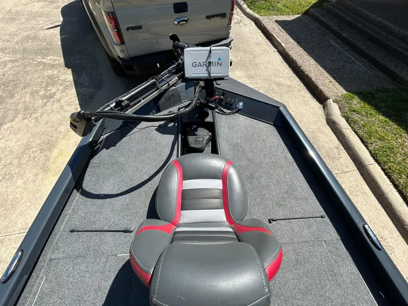 Slide: The Image of 2023 Ranger RT178 boat with Garmin system, gray and red seat, parked near a truck. - 11