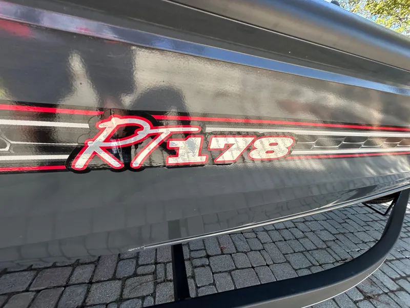 Slide: The Image of 2023 Ranger RT178 boat with red and white graphics on a dark hull. - 40
