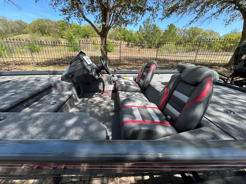 Slide: The Image of 2023 Ranger RT178 boat interior with gray and red seats, steering console, and outdoor setting. - 41