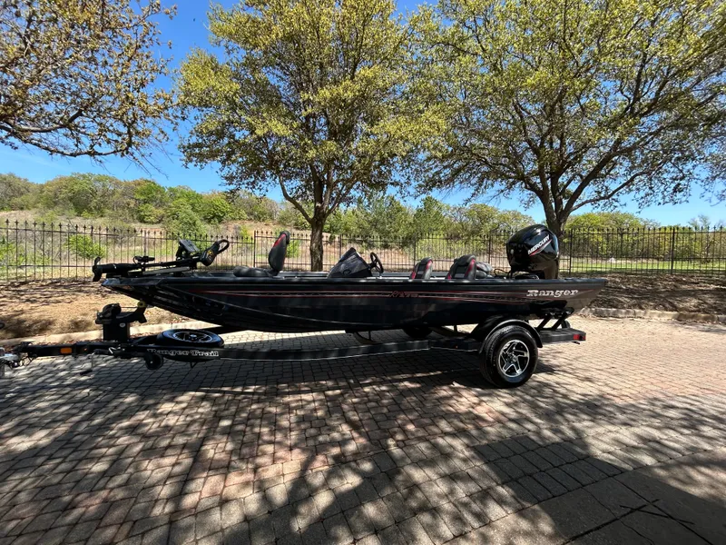 Slide: The Image of 2023 Ranger RT178 boat on trailer, parked outdoors under trees. - 49