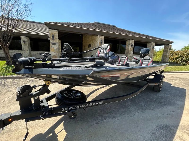 Slide: The Image of 2023 Ranger RT178 boat on trailer, parked outside a building under clear blue sky. - 5