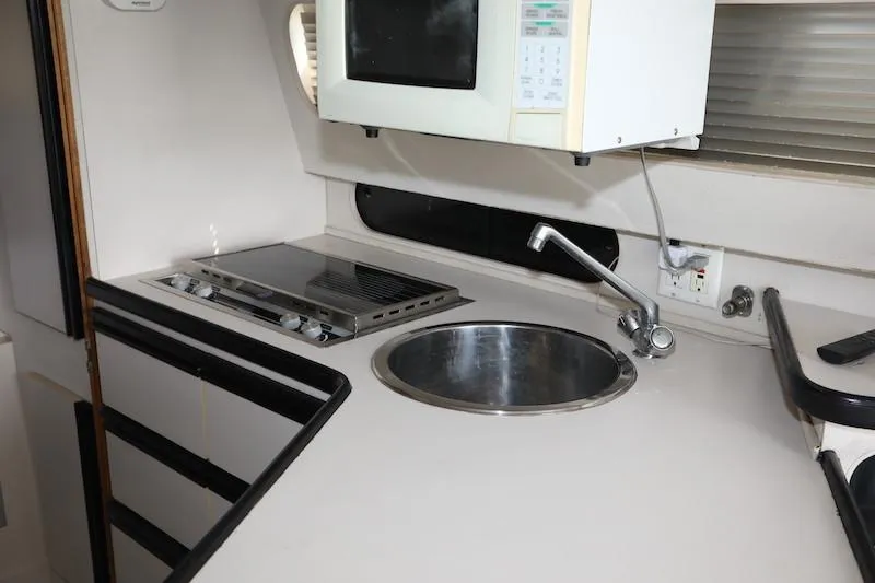 Slide: The Image of 1989 Carver 30 Santego yacht kitchen with stove, sink, and microwave. - 10