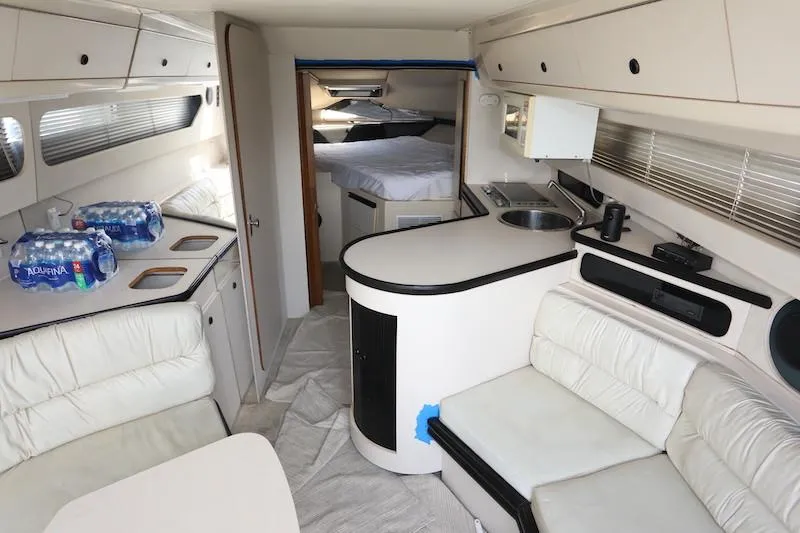 Slide: The Image of 1989 Carver 30 Santego yacht interior with seating, kitchenette, and sleeping area. - 11