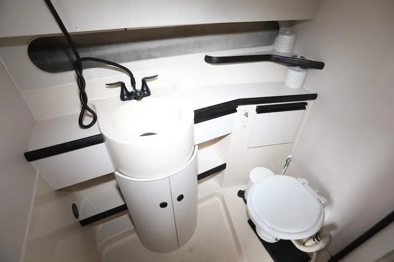Slide: The Image of 1989 Carver 30 Santego bathroom with sink, toilet, and storage shelves. - 17
