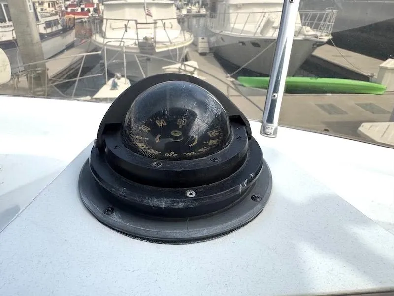 Slide: The Image of Compass on 1989 Carver 30 Santego boat, docked with other vessels in background. - 6