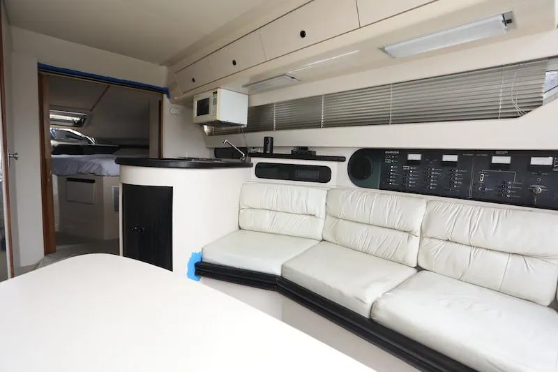 Slide: The Image of Interior of 1989 Carver 30 Santego yacht with white seating and control panel. - 12