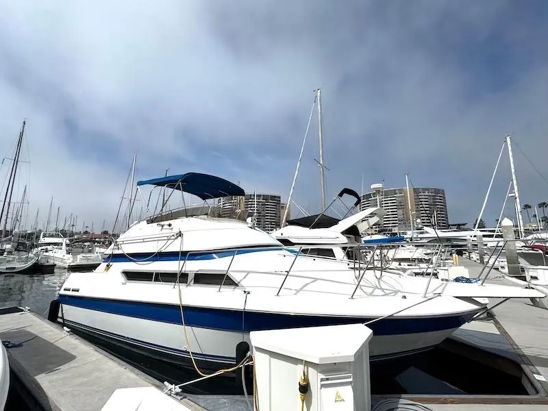 Slide: The Image of 1989 Carver 30 Santego yacht docked in a marina with other boats. - 2