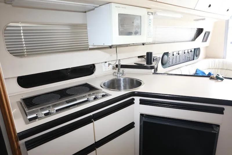 Slide: The Image of 1989 Carver 30 Santego yacht kitchen with stove, sink, and microwave. - 9