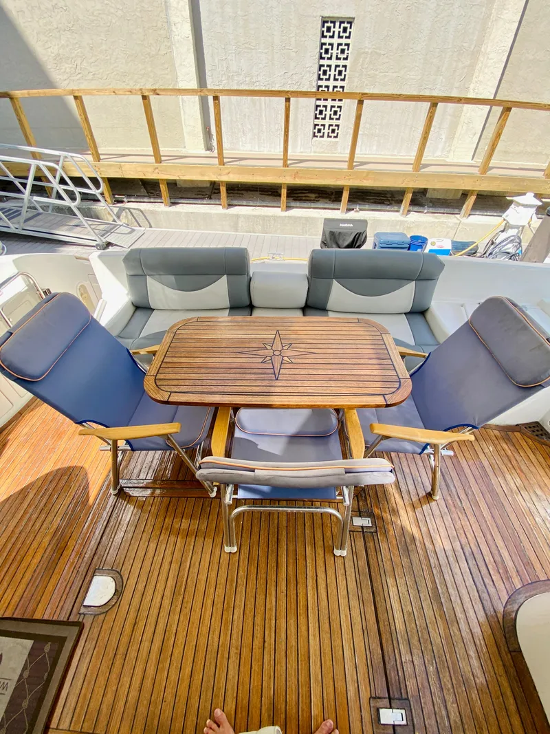 Slide: The Image of Luxury Azimut 55 yacht deck with wooden table and cushioned seating, 2002 model. - 10