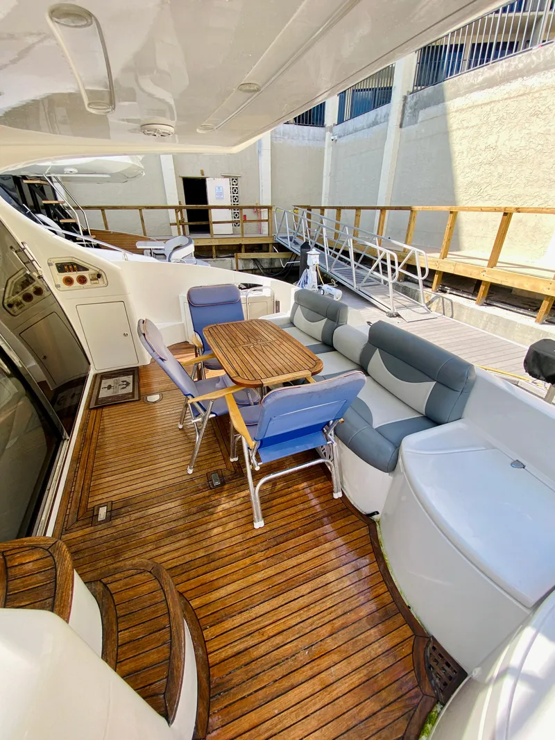 Slide: The Image of Luxurious 2002 Azimut 55 yacht deck with seating and wooden flooring. - 12