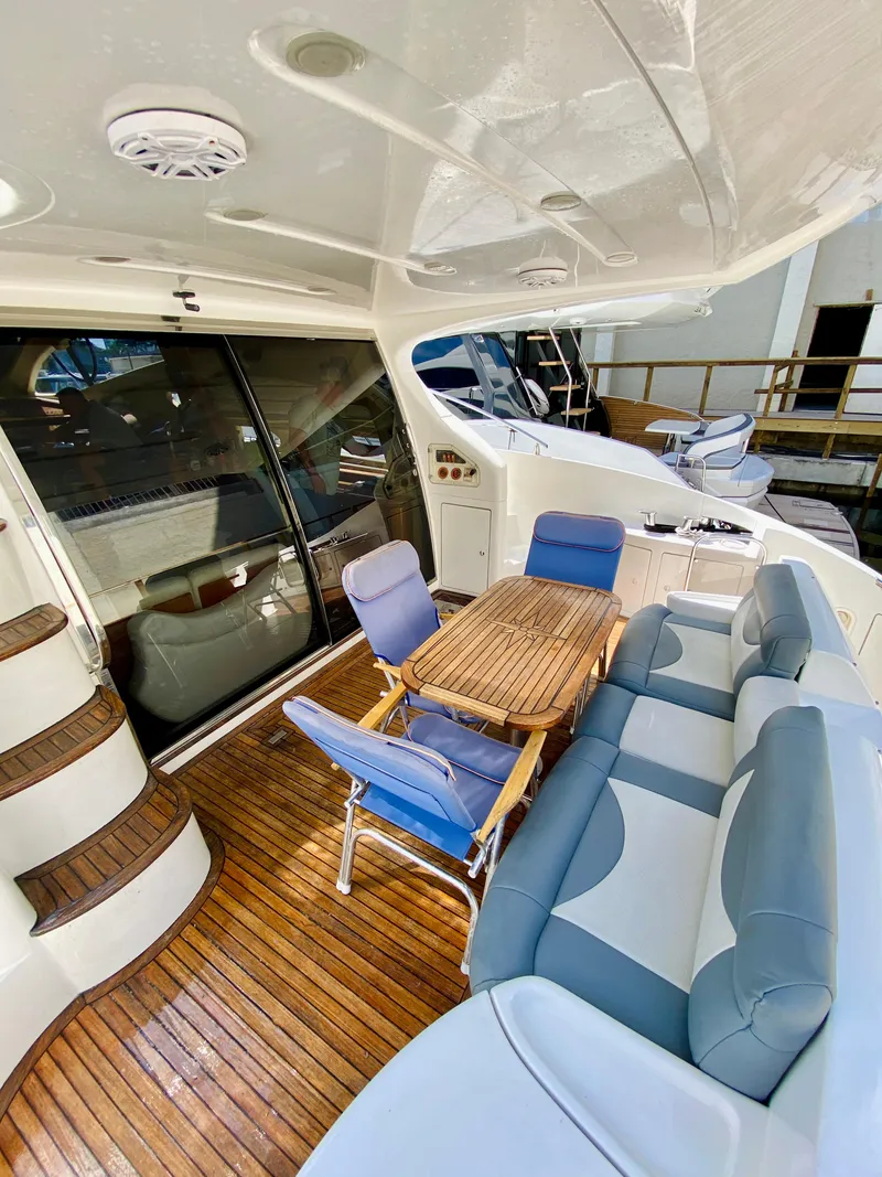Slide: The Image of 2002 Azimut 55 yacht interior with wooden deck, seating, and table. - 13