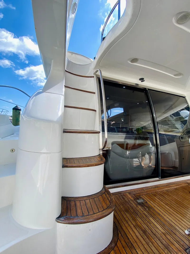 Slide: The Image of Staircase on 2002 Azimut 55 yacht with wooden deck and glass door under blue sky. - 16