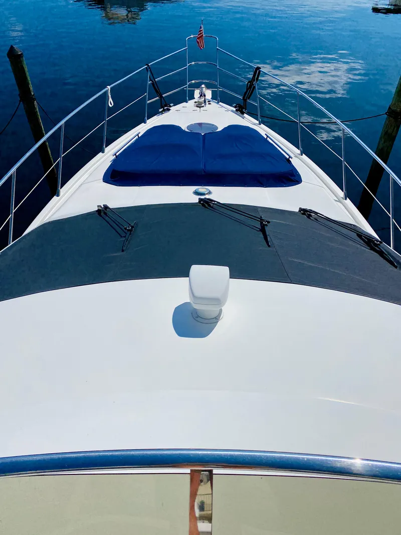 Slide: The Image of Azimut 55 yacht, 2002 model, docked with blue cushions on deck, reflecting on calm water. - 32