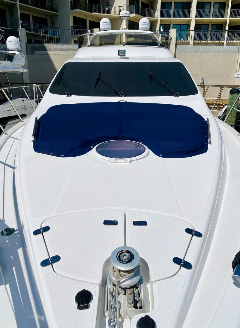 Slide: The Image of 2002 Azimut 55 yacht with sleek design and blue sunshade, docked at a marina. - 37