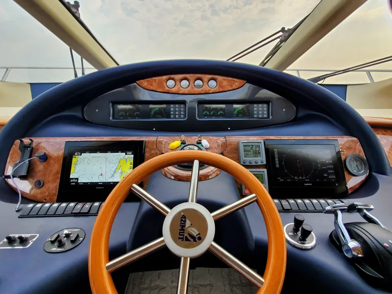Slide: The Image of Cockpit view of 2002 Azimut 55 yacht with navigation instruments and wooden steering wheel. - 48