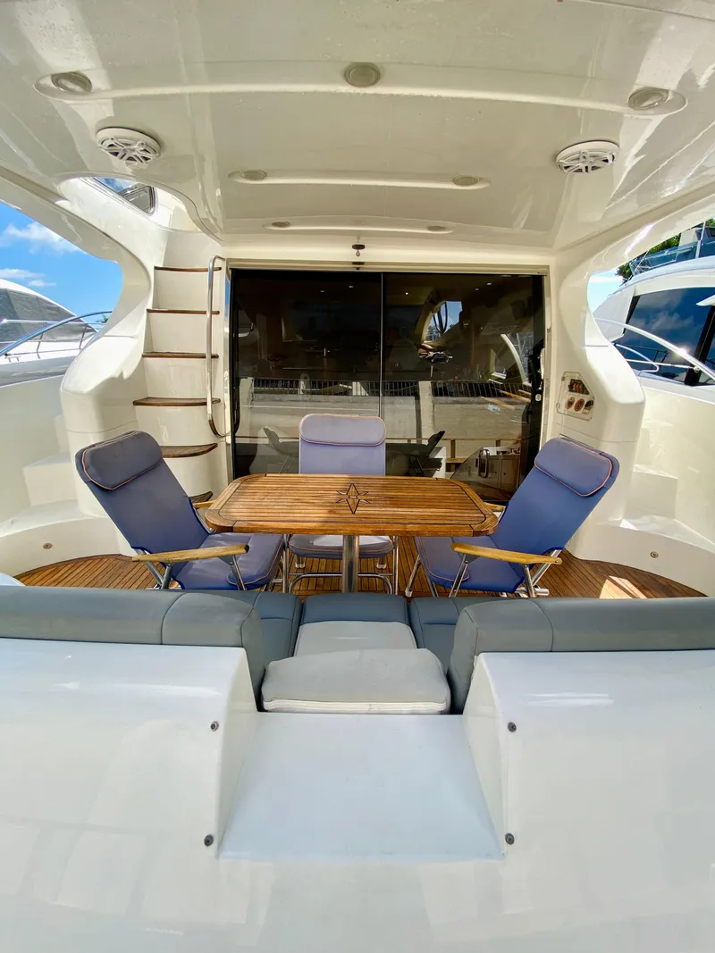 Slide: The Image of 2002 Azimut 55 yacht deck with seating and table, featuring modern design and comfort. - 7