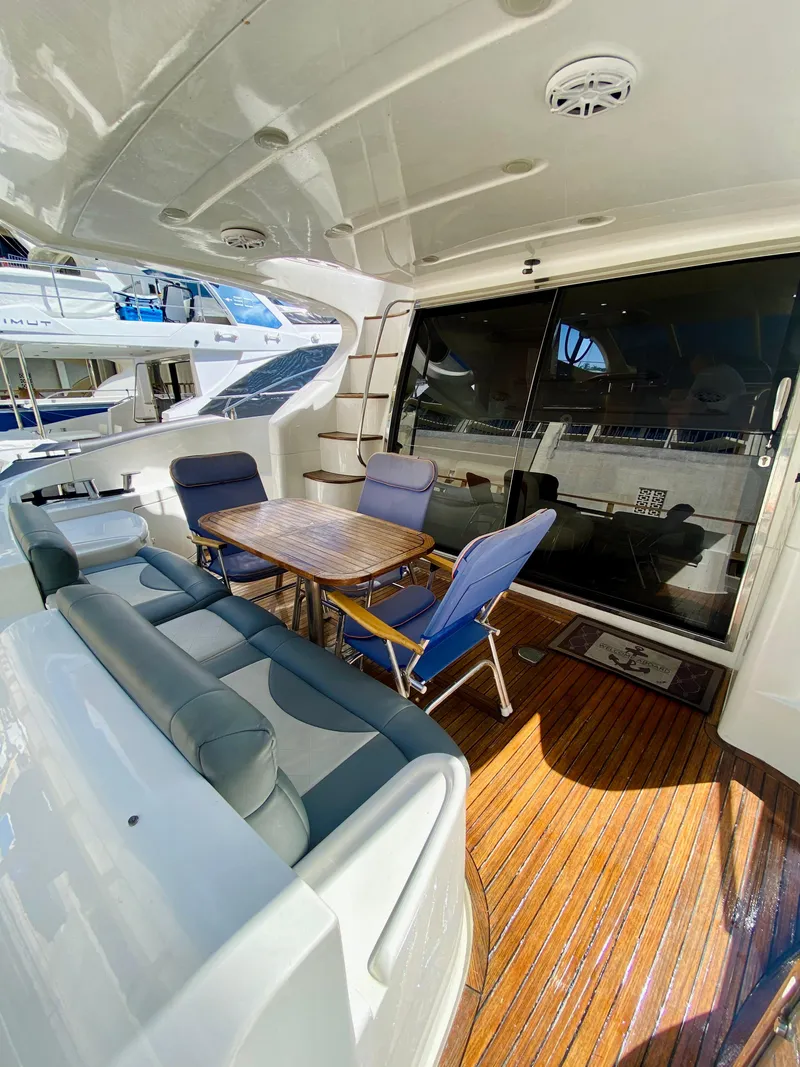 Slide: The Image of Azimut 55 yacht 2002 model, featuring a spacious outdoor seating area with wooden flooring. - 8
