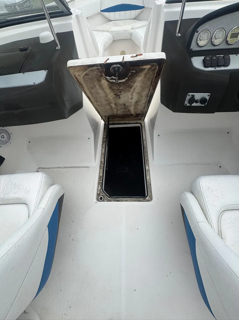 Slide: The Image of 2007 Regal 2000 Bowrider interior with open storage compartment between seats. - 13