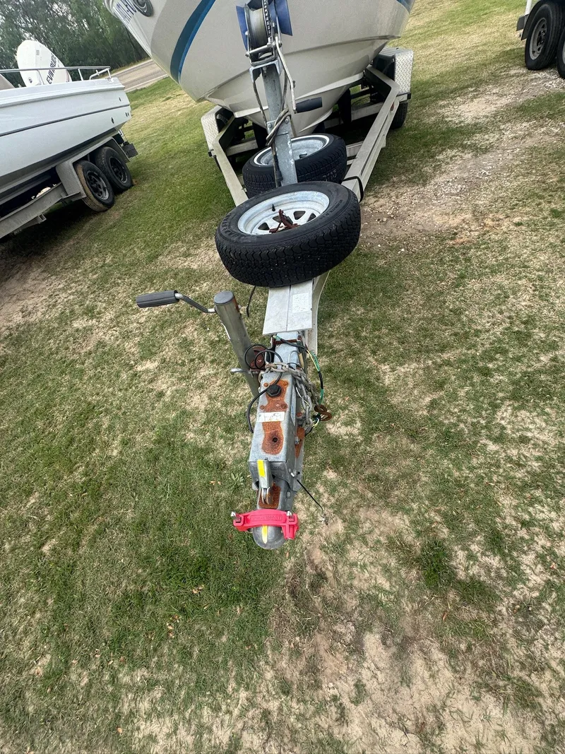 Slide: The Image of 2007 Regal 2000 Bowrider on trailer, parked on grass, with visible hitch and spare tire. - 14