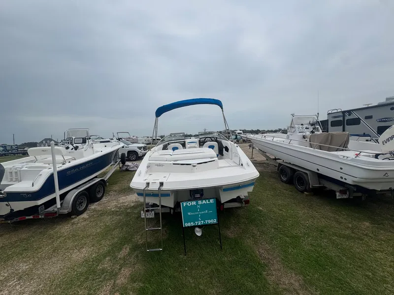 Slide: The Image of 2007 Regal 2000 Bowrider boat for sale, parked on grass with other boats. - 2