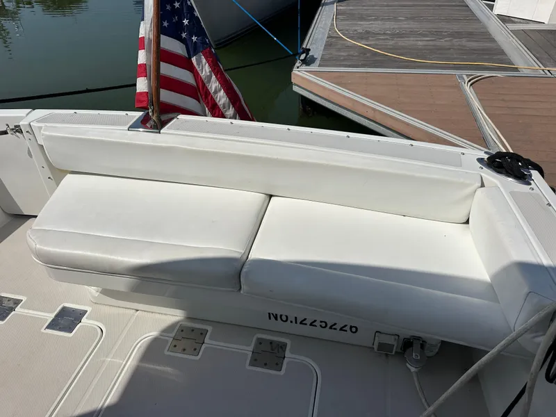 Slide: The Image of 2008 Back Cove 33 Express boat with white seating and American flag at dock. - 12