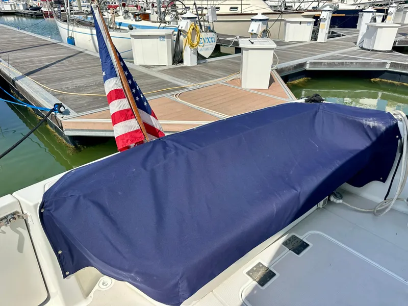 Slide: The Image of 2008 Back Cove 33 Express boat with blue cover and American flag at marina. - 13