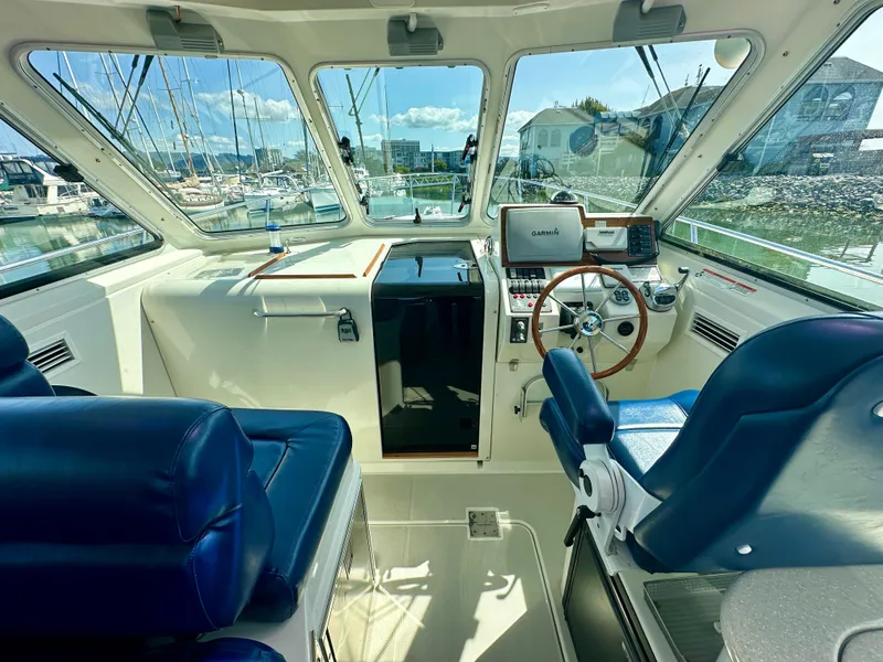 Slide: The Image of 2008 Back Cove 33 Express boat interior with blue seating and navigation equipment. - 18