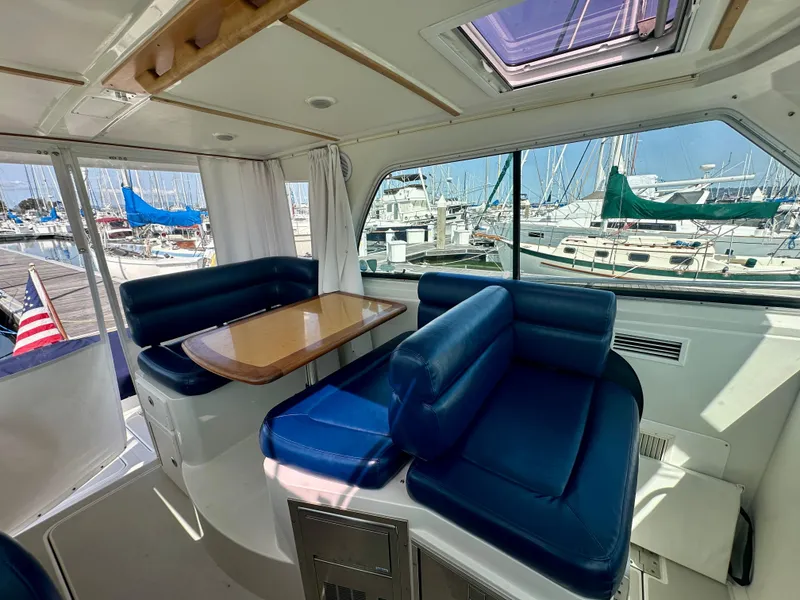 Slide: The Image of Interior of 2008 Back Cove 33 Express yacht with blue seating and wooden table, docked at marina. - 20