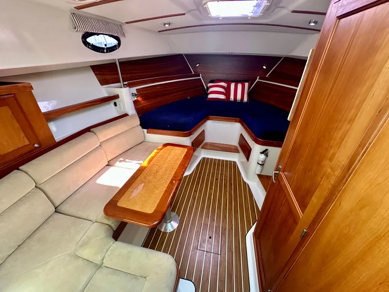 Slide: The Image of 2008 Back Cove 33 Express cabin interior with wood accents and cozy seating. - 34