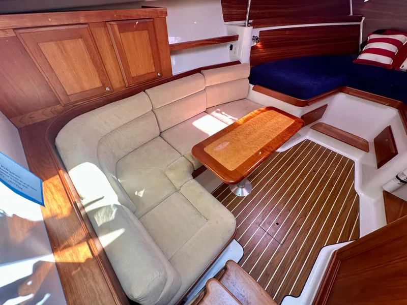 Slide: The Image of Interior of 2008 Back Cove 33 Express with beige seating and wooden table. - 36