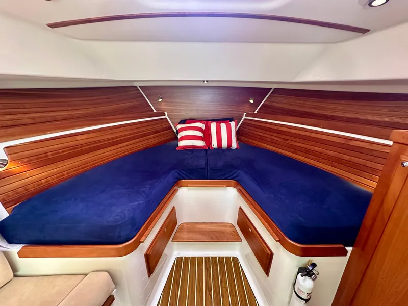 Slide: The Image of 2008 Back Cove 33 Express cabin with blue bedding and striped pillows. - 37