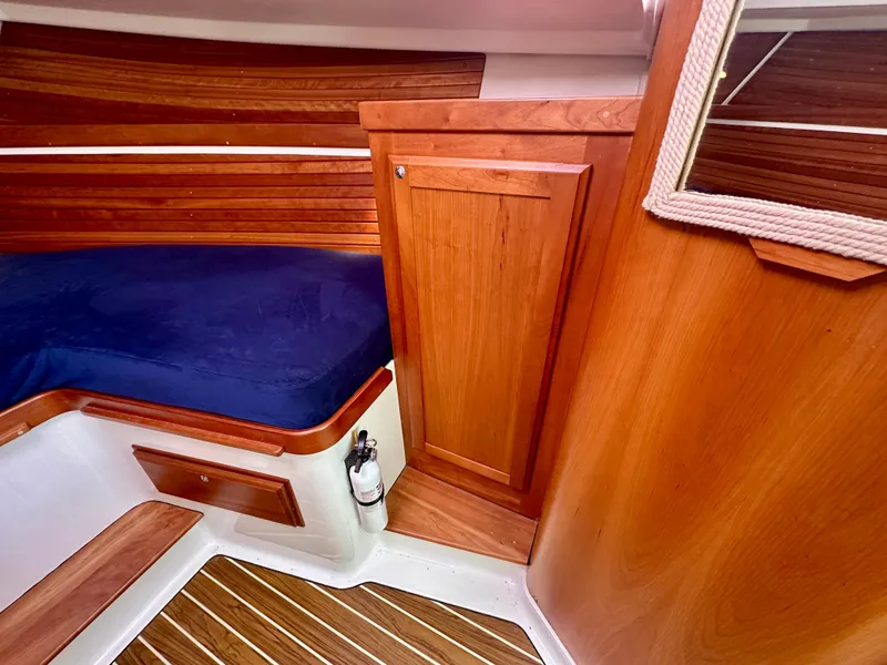 Slide: The Image of Interior of 2008 Back Cove 33 Express with wood paneling and blue cushioned seating. - 41