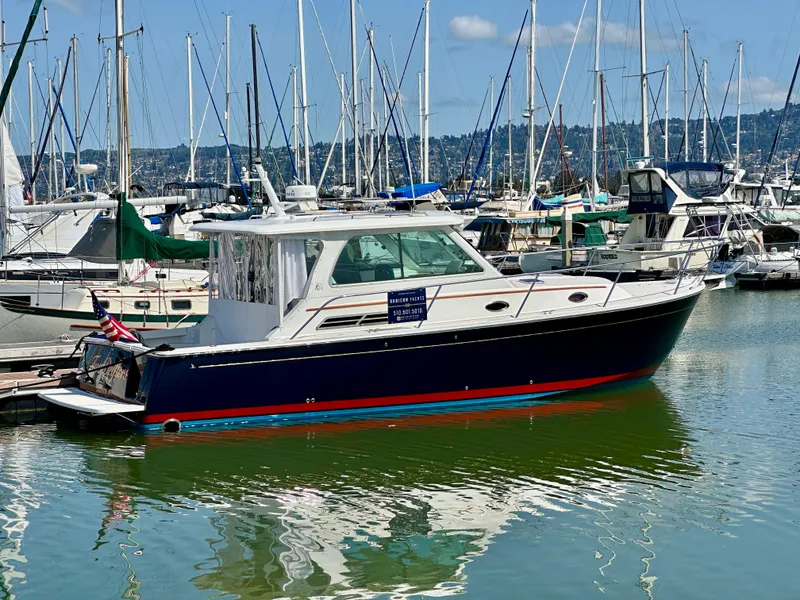 Slide: The Image of 2008 Back Cove 33 Express yacht docked in a marina, surrounded by sailboats. - 46