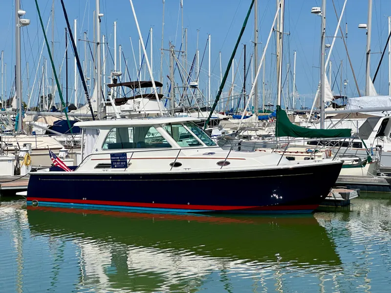 Slide: The Image of 2008 Back Cove 33 Express yacht docked in a marina, surrounded by sailboats. - 48