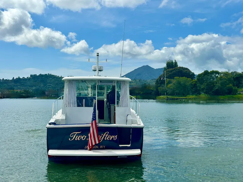 Slide: The Image of 2008 Back Cove 33 Express boat on serene lake with scenic mountain backdrop. - 5