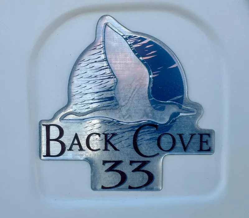 Slide: The Image of Back Cove 33 Express 2008 emblem with bird design on metallic background. - 58