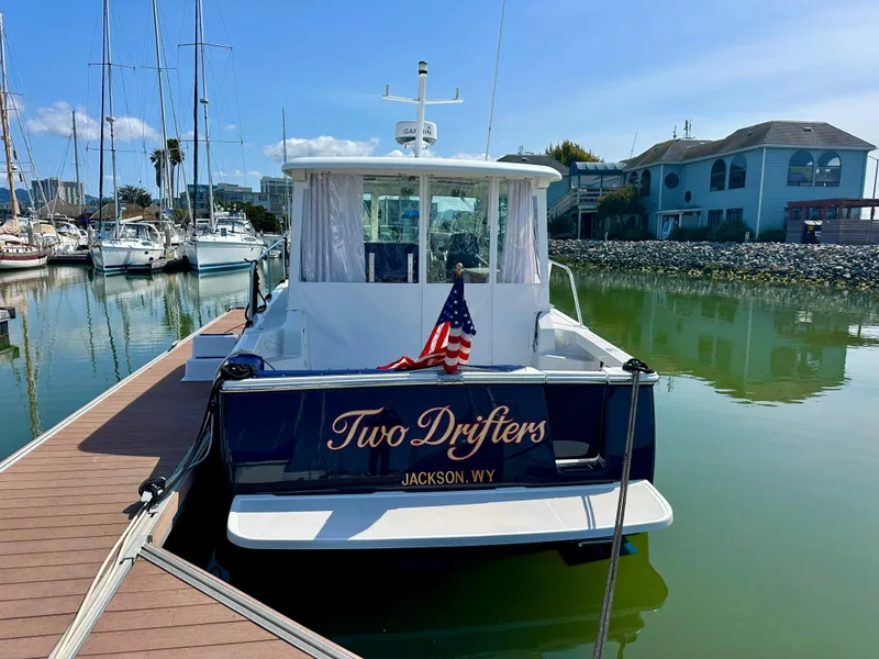Slide: The Image of 2008 Back Cove 33 Express boat docked, displaying "Two Drifters" and an American flag. - 6