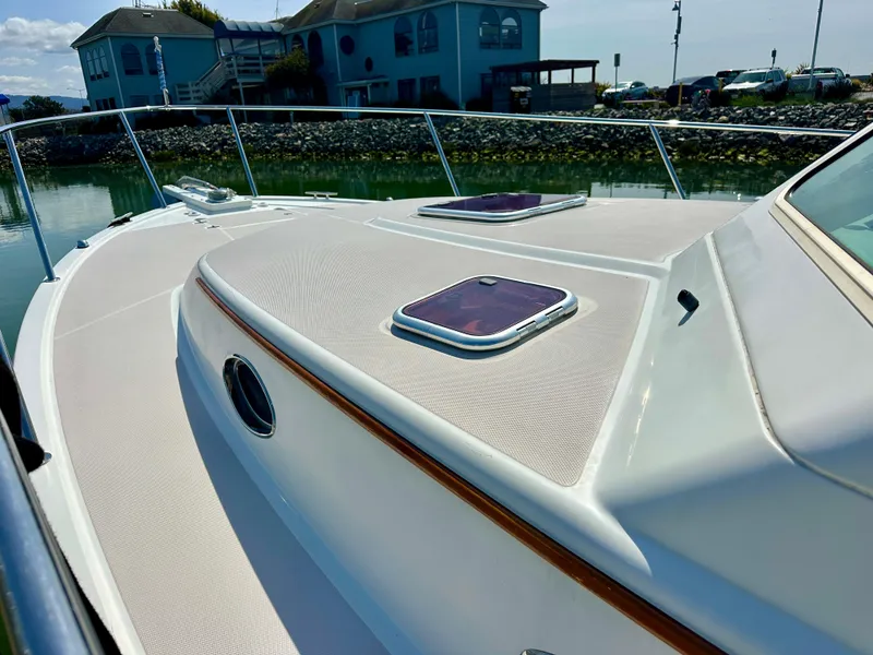 Slide: The Image of 2008 Back Cove 33 Express boat deck with hatches, docked near waterfront homes. - 7