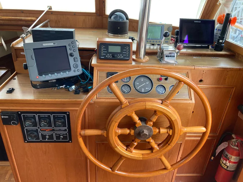 Slide: The Image of Helm of 1985 Grand Banks 42 Classic with wooden wheel and navigation instruments. - 13