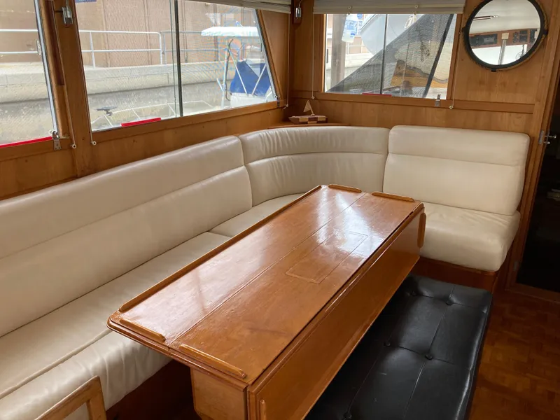 Slide: The Image of Interior of 1985 Grand Banks 42 Classic yacht with white seating and wooden table. - 18