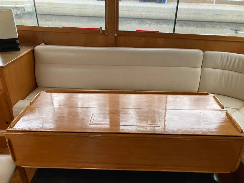 Slide: The Image of Interior of 1985 Grand Banks 42 Classic with wooden table and white cushioned seating. - 19