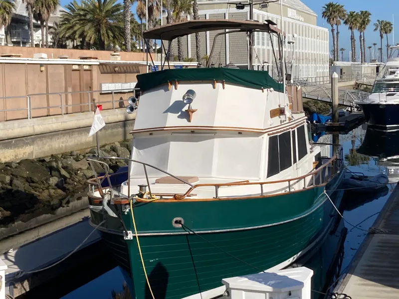 Slide: The Image of 1985 Grand Banks 42 Classic yacht docked at a marina, featuring a green hull and white cabin. - 2