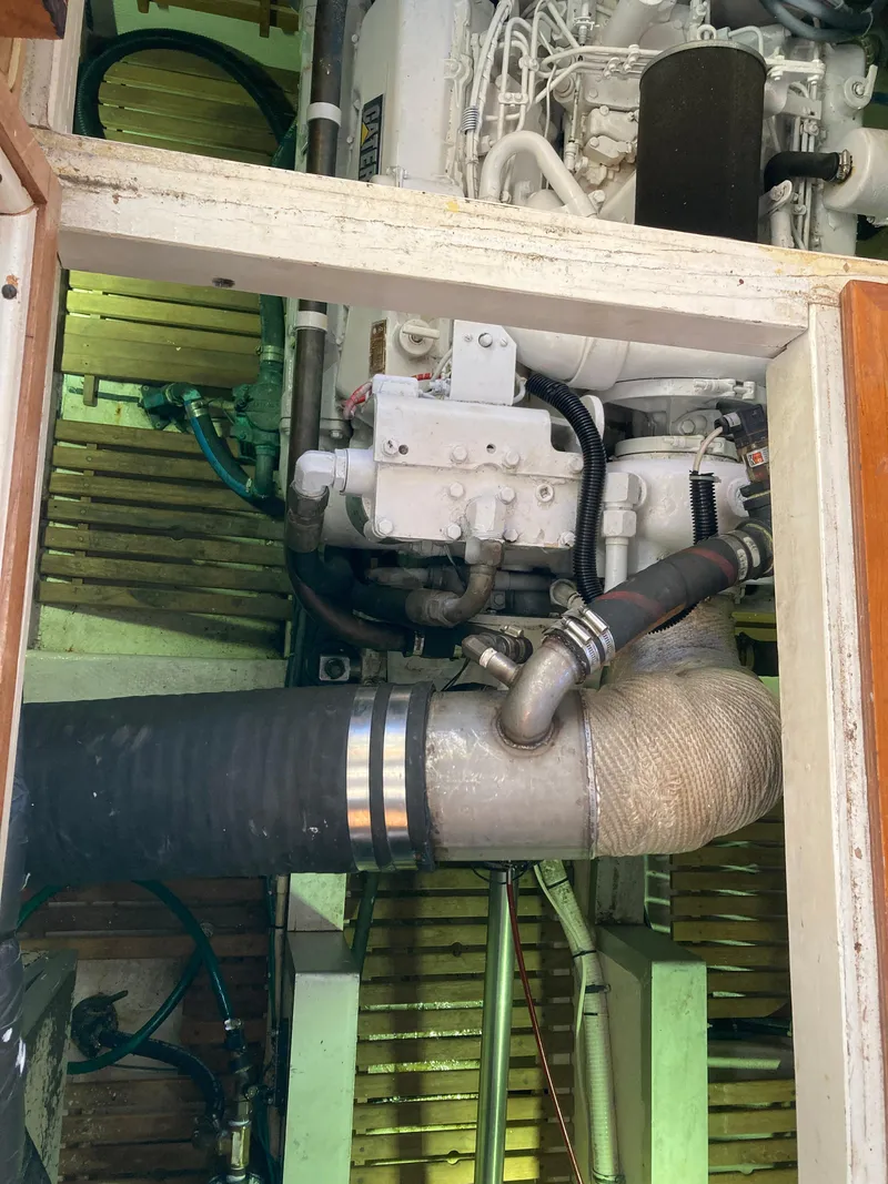 Slide: The Image of Engine room of 1985 Grand Banks 42 Classic yacht, showcasing mechanical components and piping. - 32